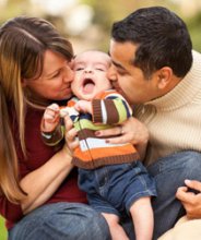mana and woman kissing infant